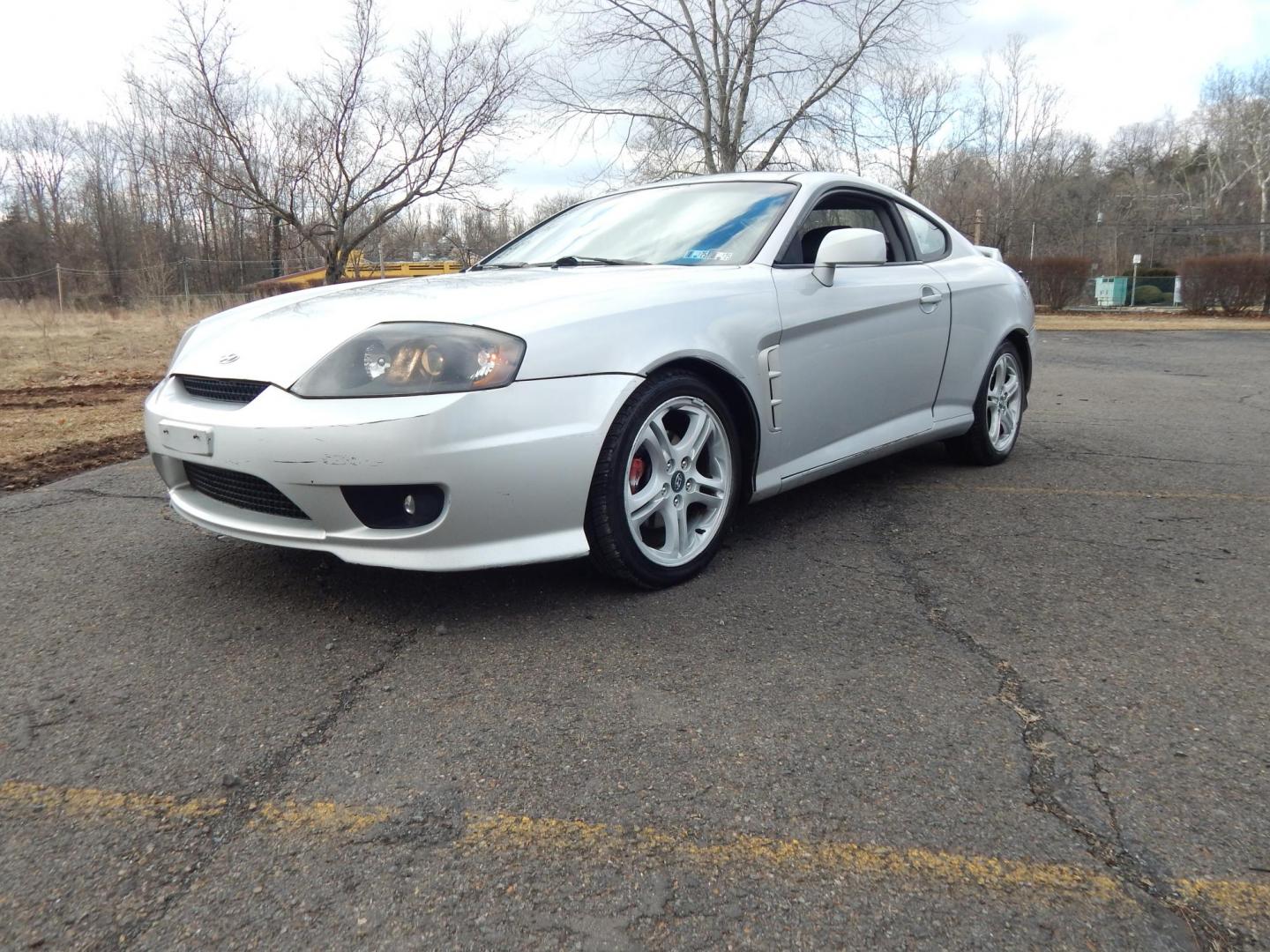 2005 Silver /Black Hyundai Tiburon SE (KMHHN65F45U) with an 2.7L V6 DOHC 24V engine, 6 Speed Manual transmission, located at 6528 Lower York Road, New Hope, PA, 18938, (215) 862-9555, 40.358707, -74.977882 - Here we have a Hyundai Tiburon with a 2.7L V6 putting power to the front wheels via a smooth shifting manual transmission. Options include: black leather with red insert seats, heat and A/C, JVC head unit, power windows/locks/mirrors, sunroof, cruise control, tilt steering wheel, IB. FT/MPG/Volt gau - Photo#0