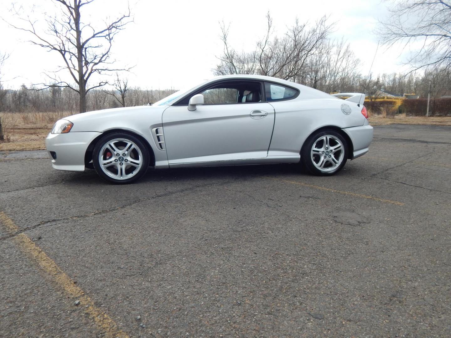 2005 Silver /Black Hyundai Tiburon SE (KMHHN65F45U) with an 2.7L V6 DOHC 24V engine, 6 Speed Manual transmission, located at 6528 Lower York Road, New Hope, PA, 18938, (215) 862-9555, 40.358707, -74.977882 - Here we have a Hyundai Tiburon with a 2.7L V6 putting power to the front wheels via a smooth shifting manual transmission. Options include: black leather with red insert seats, heat and A/C, JVC head unit, power windows/locks/mirrors, sunroof, cruise control, tilt steering wheel, IB. FT/MPG/Volt gau - Photo#1